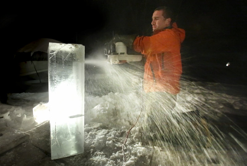 Gregory Rec/Staff Photographer: Ice sculptor Jesse Bouchard uses an electric chainsaw to cut out a detail area on a block of ice at his South Portland home on Tuesday, February 12, 2013. The blocks will be constructed into an ice bar at the Hilton Garden Inn in Freeport on Friday night.