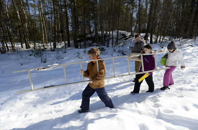 Joe Guenther, 11, leads classmates carrying a ladder into the woods so his group can hang a nesting box for northern flickers as part of the Center for Teaching and Learning’s hands-on scientific research that their teacher feels is essential to a child’s development.