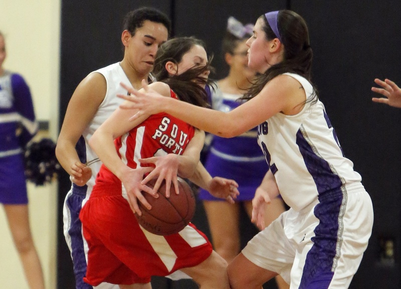 South Portland’s Maddie Hasson gets caught between Deering’s Keneisha DiRamio, left, and Chelsea Saucier Monday night in Portland.