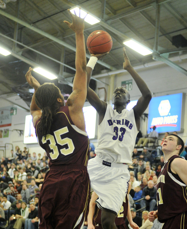 Labson Abwoch of Deering looks to shoot over Malcolm Dopwell of Thornton Academy during their Western Class A quarterfinal at the Portland Expo. Seventh-seeded Thornton upset the No. 2 Rams in overtime, 49-40.