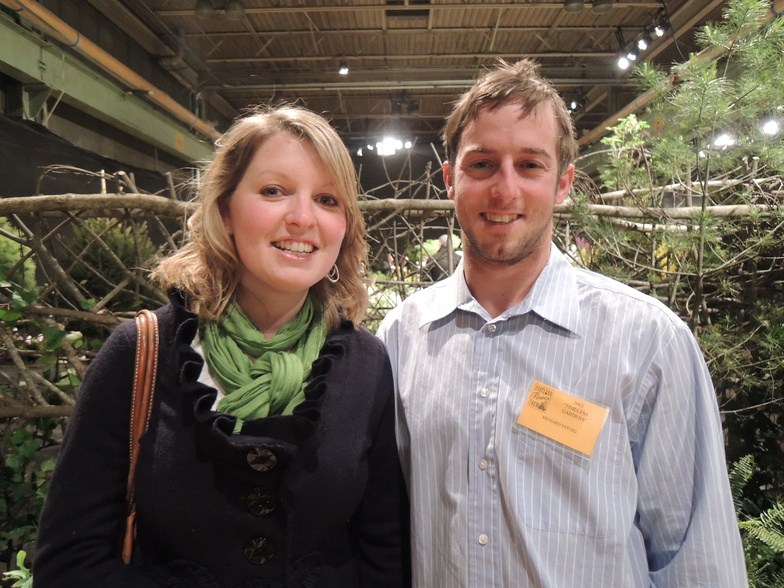 Jill Fitzpatrick and Toby Jacobs of Portland walk through the “Maine in the Shade” garden by Cozy Acres Greenhouse, which received the Beatrix Farrand Design Award.