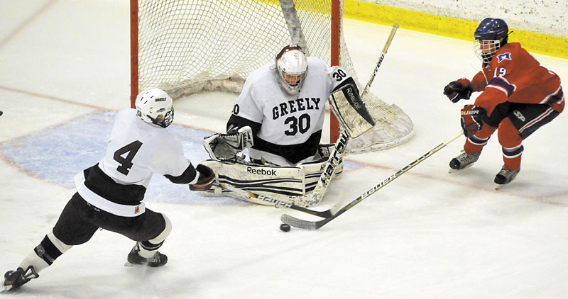 Messalonskee's Jared Cunningham, right, tries to get a shot off on Greely goalie Kyle Kramlich as Miles Shields defends in the second period of the Class B state championship game at the Colisee in Lewiston.