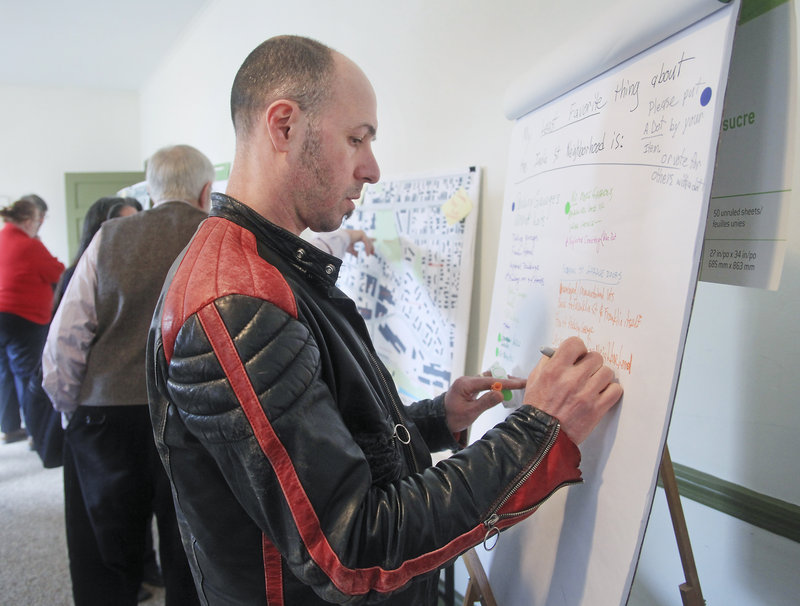 Markos Miller, a Munjoy Hill resident, shares his opinion on a comment board at Saturday’s open house. “The neighborhood is right between the city and the water. I also like its sense of opportunity,” he said.