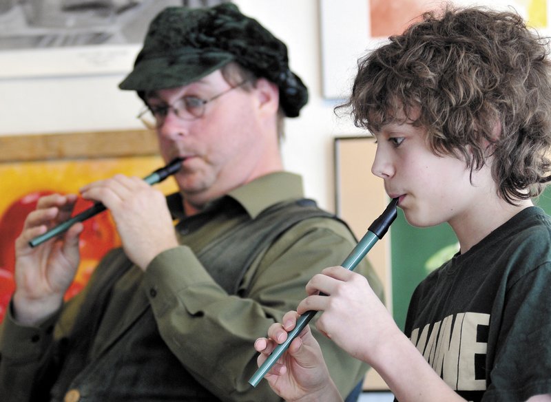 Adam Soosman, left, and Will Fahy, 13, play tin whistles Sunday at the Harlow Gallery in Hallowell. The duo played traditional Irish songs on the instruments during a fundraiser at the gallery on St. Patrick’s Day.