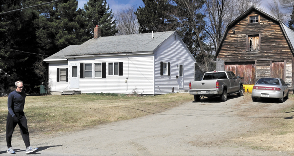 A walker goes past 202 Maple Ave. in Farmington where two people committed suicide Monday, police say.