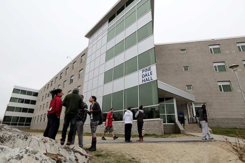 UMASS-Dartmouth students stand outside he Pine Dale Hall dormitory that Dzhokhar Tsamaev, lived in on Friday, April 19, 2013 in Dartmouth, Mass., as students were evacuated from campus on Friday, April 19, 2013, as local and state officials investigate the dorm room of Tsarnaev, 19, one of the two suspects wanted for the Boston Marathon bombing on Monday. The campus closed down along with colleges around the Boston area. (AP Photo/Standard Times, Peter Pereira) crime;terrorism;bomb;investigation;police;military