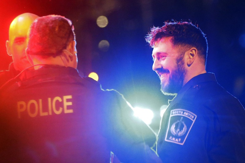 Police officers smile to fellow officers as they leave the scene after the arrest of a suspect of the Boston Marathon bombings in Watertown, Mass., Friday, April 19, 2013. A 19-year-old college student wanted in the Boston Marathon bombings was taken into custody Friday evening after a manhunt that left the city virtually paralyzed and his older brother and accomplice dead. (AP Photo/Matt Rourke)