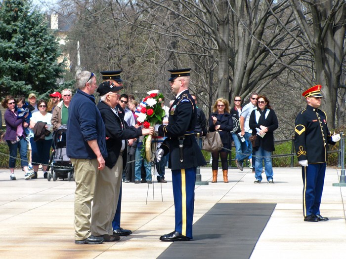 Overcome with emotion, veteran Richard Leighton of Westbrook (at center in ballcap) hands over a memorial wreath bearing the name of his late brother, Sgt. Raymond Leighton, to a member of the honor guard at the Tomb of the Unknown Soldier at Arlington National Cemetery on Sunday. Sgt. Leighton was killed in action in Vietnam. Coordinators of the program Honor Flight New England surprised Leighton and his son, Rick (at left) with the wreath-laying ceremony during a trip to Washington, D.C.