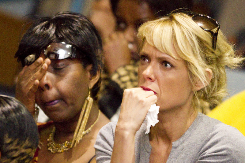 Claudette Muteteli, left, a native Rwandan, and friend Kellisha Decarlo react while watching a documentary about genocide in Rwanda during the 19th Commemoration of Genocide against the Tutsi on Sunday. Muteteli is the only one of her nine immediate family members who escaped the genocide of 1994 that killed more than 800,000 Tutsis.