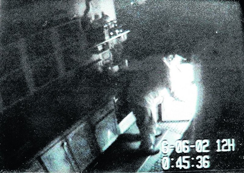 An intruder believed to be Christopher T. Knight inspects a refrigerator in a Rome-area camp.