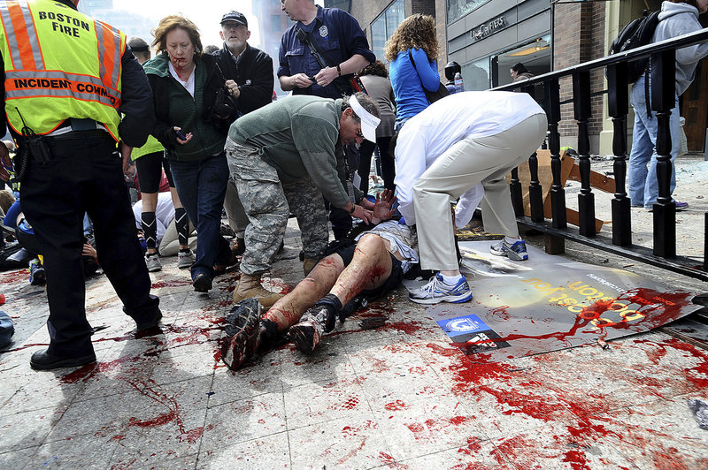 An injured person is helped on the sidewalk near the finish line after Monday’s explosions. Some victims were treated in a medical tent that had been set up to assist fatigued runners.