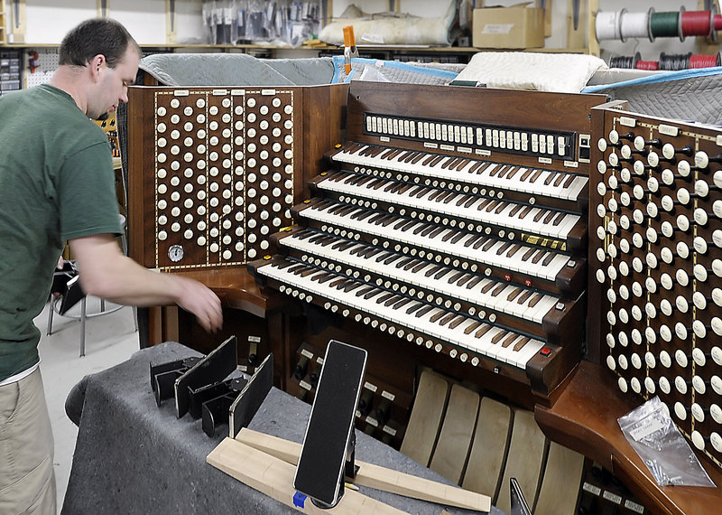 Adam Loagocki works on the console of Portland’s Kotzschmar Organ. He is part of a team of experts who will make the organ “sing” again.