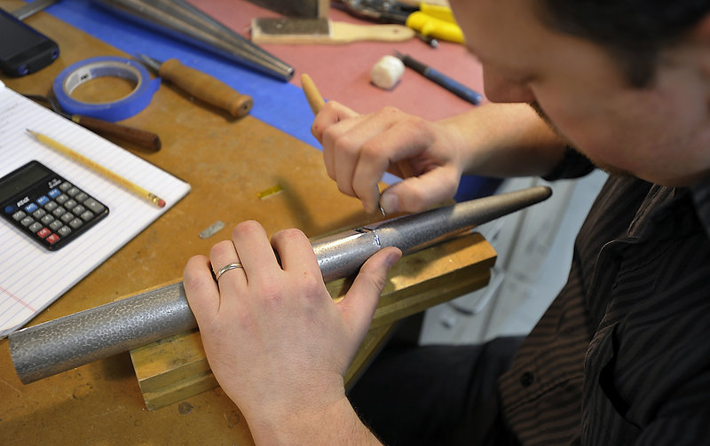 Milovan Popovic, known as a voicer, repairs and adjusts an organ pipe to prepare it to “sing properly.”