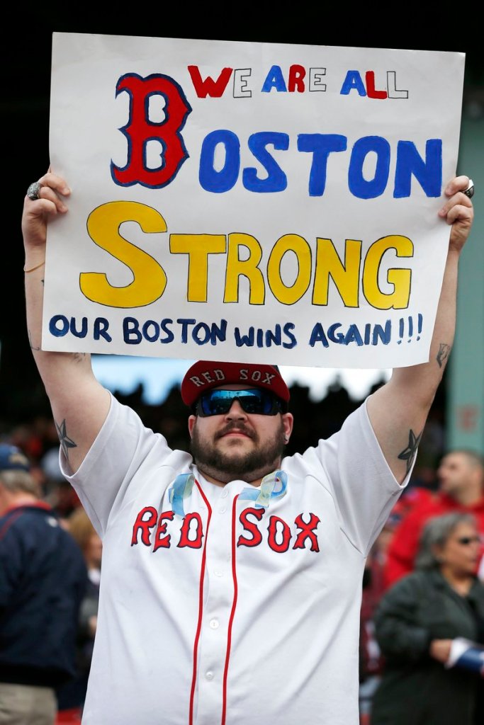 A fan holds a sign expressing the city’s mood after the Boston Red Sox defeated the Kansas City Royals at Fenway Park on Saturday. Victims and survivors of the Boston Marathon bombings were honored in an emotional pregame ceremony.