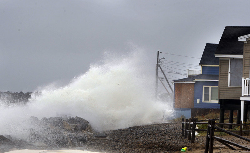 A wave comes over a sea wall in Saco near houses on Eagle Avenue during high tide on Monday, October 29, 2012. The Army Corps of Engineers has begun soliciting public comments on its long-awaited updated proposal to stabilize the shoreline at Camp Ellis Beach in Saco, an area often pummeled by bad weather and beset with erosion.