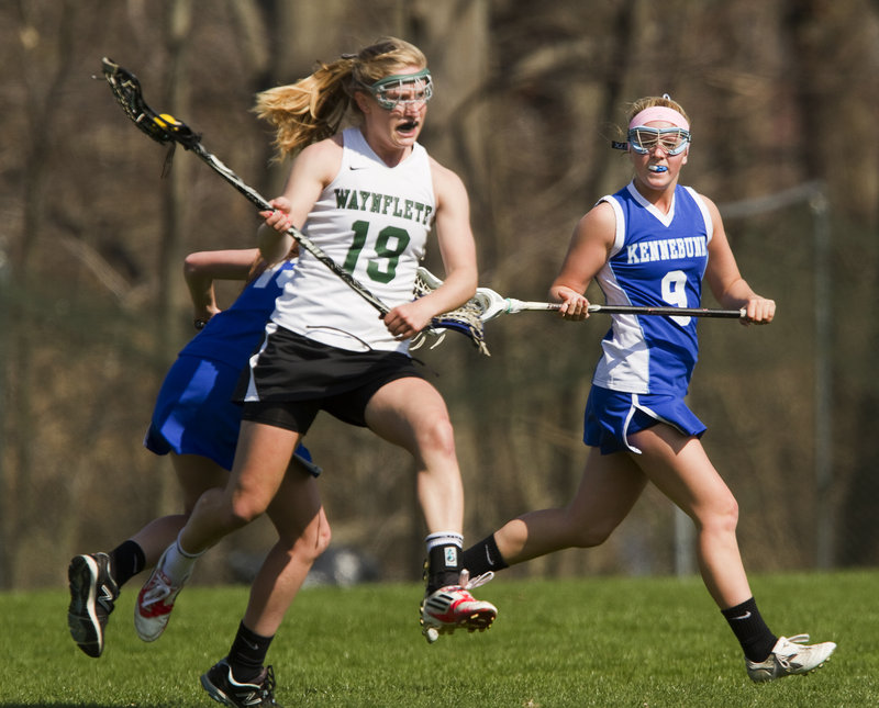 Martha Veroneau of Waynflete quickly moves the ball down the field Saturday as Samantha Bell, right, of Kennebunk pursues. Veroneau had five goals and four assists as the Flyers reached 3-0 with a 16-1 victory at home.