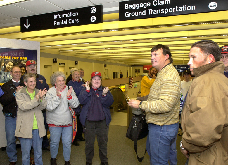 Staff Photo by John Patriquin, Tue, Apr 01, 2003: Portland Sea Dogs loyal fans Carol Spencer, Shirley Bibber, and Susie Konkel greet Sea Dogs manager Ron Johnson and pitcher James Johnson as the team arrived at the Portland Jetport tonight.