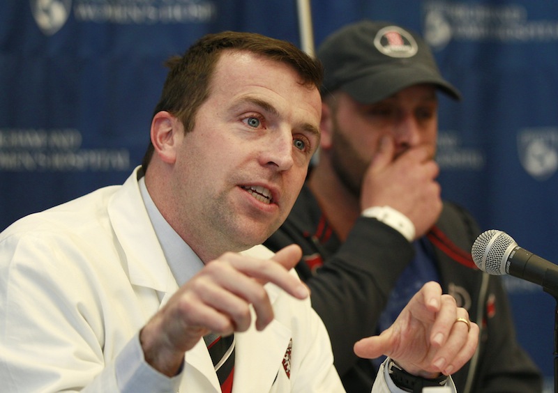 Surgeon Dr. Robert Riviello, left, describes injuries sustained by Boston Marathon explosion survivor Jarrod Clowery, of Stoneham, Mass., right, during a news conference at Brigham and Women's Hospital in Boston, Mass., Tuesday, April 30, 2013. Clowery suffered severe burn and shrapnel wounds in the bombings that killed three people and wounded more than 260 others. (AP Photo/Charles Krupa)