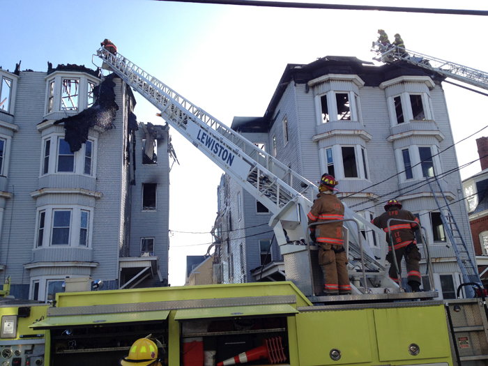 Firefighters work at the Bartlett Street apartment buildings that burned Monday morning.