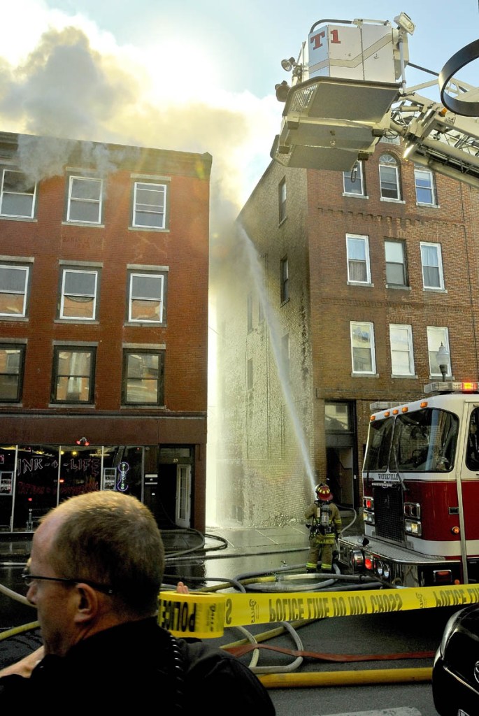 Main Street in Waterville is closed as firefighters work in an alley to extinguish fires in the facing building Friday afternoon.