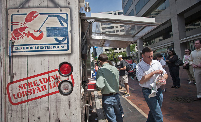 A customer leaves with lunch as dozens of others line up to purchase their own at The Red Hook Lobster Pound DC food truck in Washington D.C.