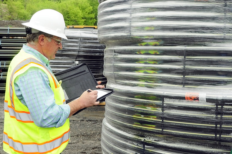 Bruce Madore, director of engineering and construction, looks over natural gas pipes Friday in the Summit Natural Gas of Maine yard in Augusta. Summit is poised to undertake major multimillion-dollar pipeline construction projects in both central and southern Maine.