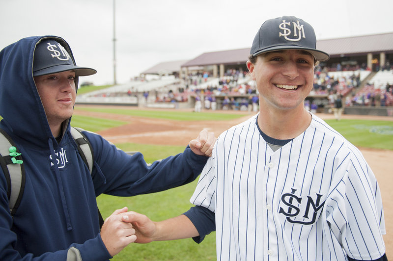 Tyler Leavitt gets congratulated after throwing a four-hit shutout Monday in the Huskies’ 8-1 win over Wisconsin-Stevens Point.
