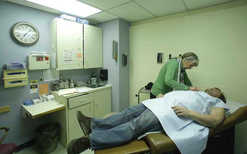 In this December 2012 file photo, Peggy Akers, a nurse practitioner who volunteers at the India Street Public Health Clinic in Portland, examines Charles Lafland during a physical exam at the clinic. Gov. Paul LePage vetoed a Medicaid-expansion bill on Monday, June 17, 2013, denying 60,000 low-income Mainers health care under the Affordable Care Act. House Democrats' last-ditch effort to override the veto came up three votes short on Wednesday, June 19, 2013.