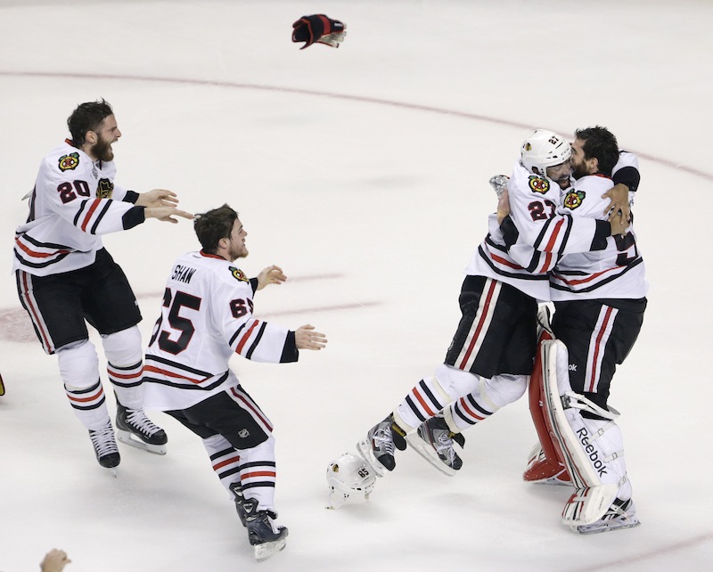 Chicago Blackhawks defenseman Johnny Oduya (27), of Sweden, hugs Chicago Blackhawks goalie Corey Crawford (50) after winning Game 6 of the NHL hockey Stanley Cup Finals 3-2 against the Boston Bruins, Monday, June 24, 2013, in Boston. (AP Photo/Charles Krupa) TD Garden