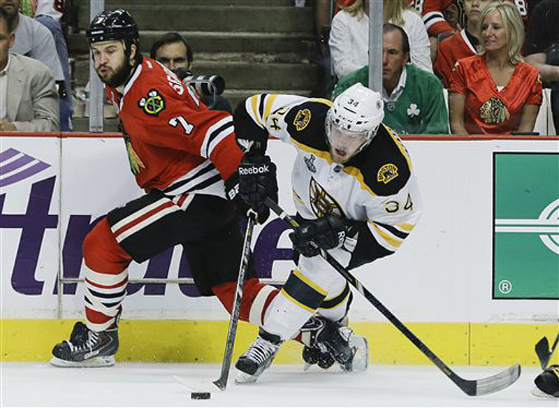 Chicago Blackhawks defenseman Brent Seabrook gets tangled up with Boston Bruins center Carl Soderberg during Game 5 of the NHL hockey Stanley Cup Finals on Saturday in Chicago.