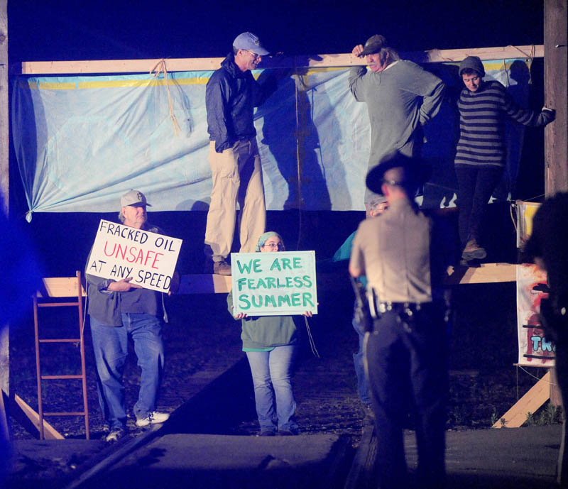 Protesters from 350 Maine block the railroad crossing at Lawrence Avenue in Fairfield Thursday night, to protest the transport of fracked oil.