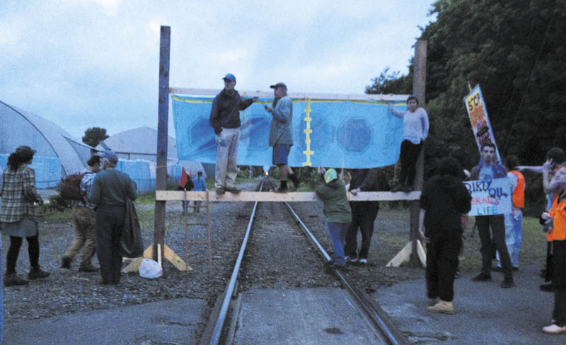 Protesters from a group calling itself 350 Maine erect a barricade on railroad tracks near the Fairfield Town Office Thursday evening. The group said in a release that they were trying to stop a train allegedly carrying fracked oil from North Dakota.