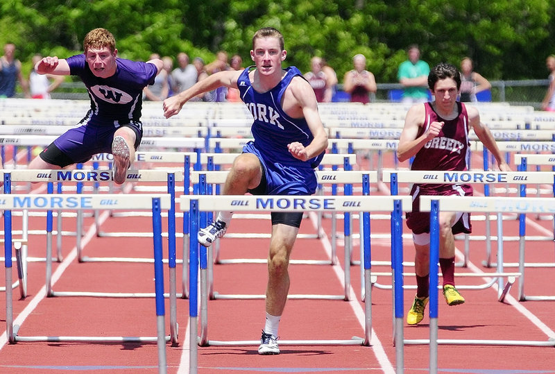 Tom Reid, center, of York captures the 110-meter hurdles in 15.43 seconds, finishing ahead of Jordhan Levine, left, of Waterville, who was second, and Ben Giffard of Greely.