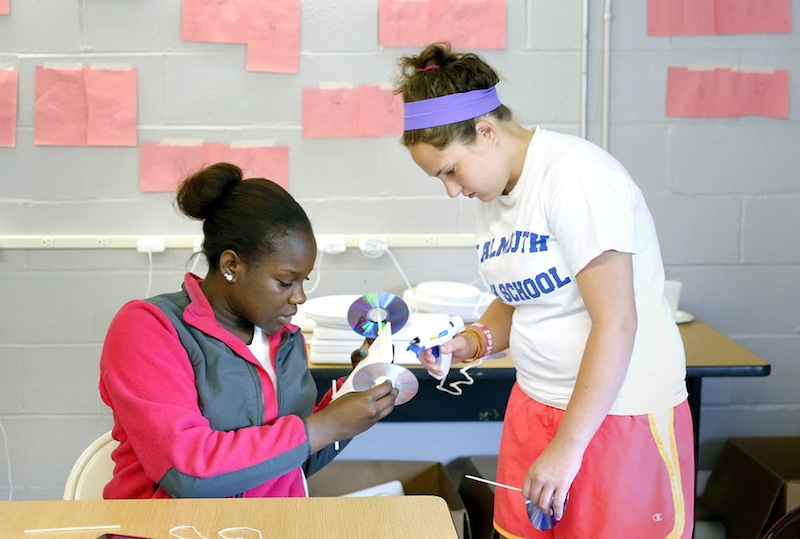 Chantelle King, 15, from Windham High School, left, and Julia Kaserman, 17, from the Real School, glue a cd for a wheel while building a mousetrap car at the Real School on Mackworth Island in Falmouth on July 10, 2013. A group of 16 girls are wrapping up a free, three-week STEM (science, technology, engineering, math) program, working with local companies to solve “real world” problems.