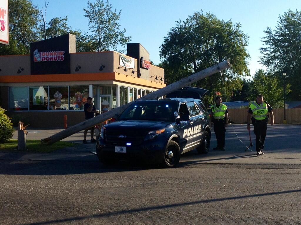 A utility pole snapped and fell on top of a WIndham police vehicle Tuesday night as the officer was pulling out of Dunkin' Donuts in North Windham.