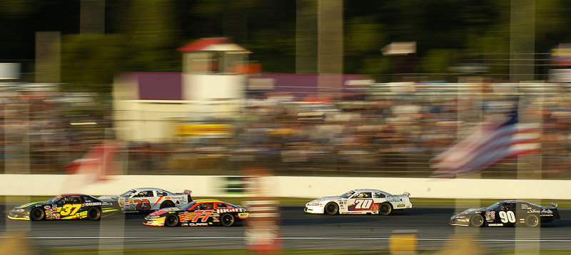 Race cars streak down the backstretch at Oxford Plains Speedway on Sunday, where Travis Benjamin of Morrill beat Berwick’s Joey Doiron, the current PASS North points leader.