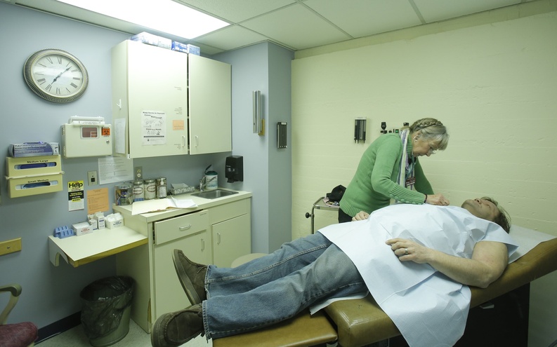 In this December 2012 file photo, Peggy Akers, a nurse practioner who volunteers at the India Street Public Health Clinic in Portland, examines Charles Lafland during a physical exam at the clinic. States have begun tackling an issue that has vexed employers, individuals and governments at all levels for years: trying to control the rapidly rising cost of health care. Maine has an especially difficult task because it ranks fifth among the states for per-capita health care costs, according to 2009 federal statistics.