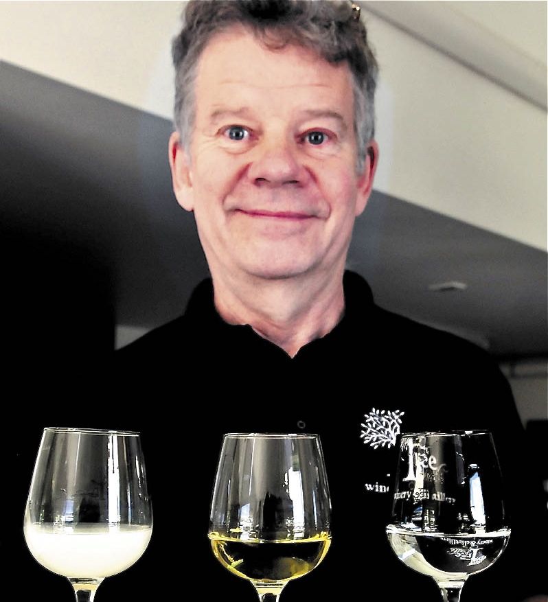 Bruce Olson, co-owner of Tree Spirit Winery, holds a tray of absinthe in different stages of production at the Oakland company. At left is a glass of absinthe in the Louche phase, a more flavorful version that turns white after water is added. The center glass is the finished version that is more potent, with a green tint from added herbs. At right is the clear, beginning phase.