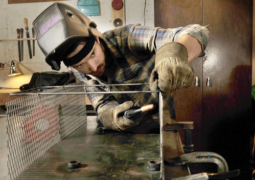 Metal fabricator John Nelson welds a basket at his Portland shop.