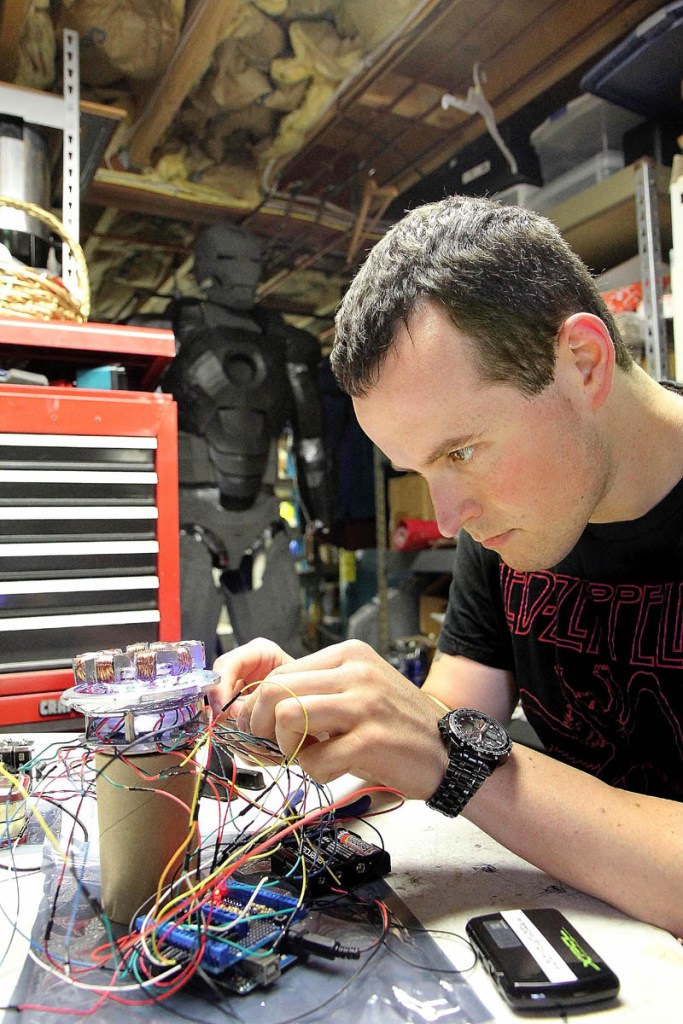 Thomas Lemieux works on an arc reactor to go on his life-size Iron Man costume, in the basement of his Oakland home recently. Lemieux, 28, said he plans to wear the costume at the Hawthorne Hotel's Halloween Ball on Oct. 26 in Salem, Mass.