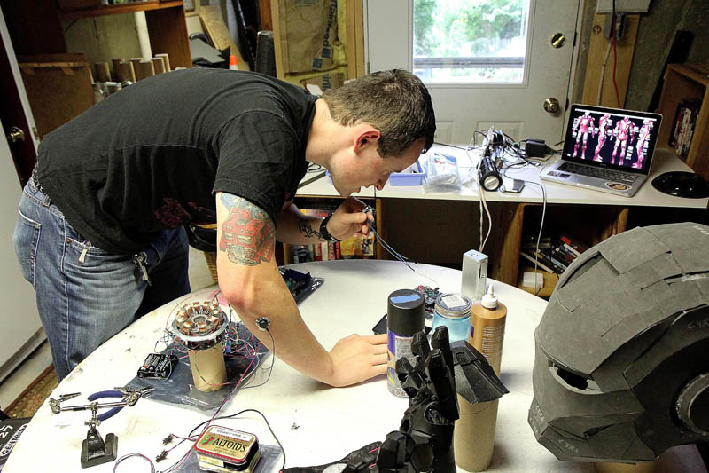 Thomas Lemieux works on a voice changer for his life-size Iron Man costume, in the basement of his Oakland home, recently.