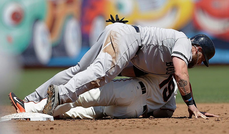 Boston’s Jonny Gomes lies on top of Giants second baseman Marco Scutaro after being tagged out during third-inning action of Wednesday afternoon’s game in San Francisco, won convincingly by the Red Sox. AT&T Park