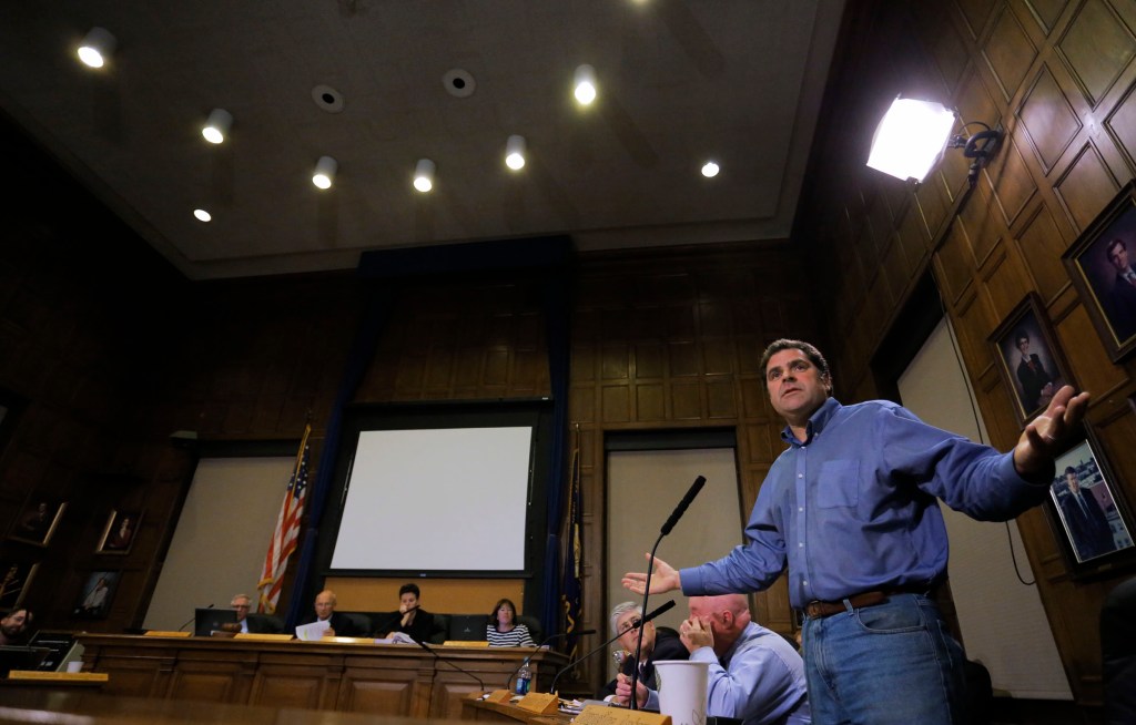 Portland City Councilor John Anton raises his hands in exasperation while discussing the proposed sale of Congress Square Plaza to an Ohio investment firm during the city council meeting Monday, Sept. 16, 2013.