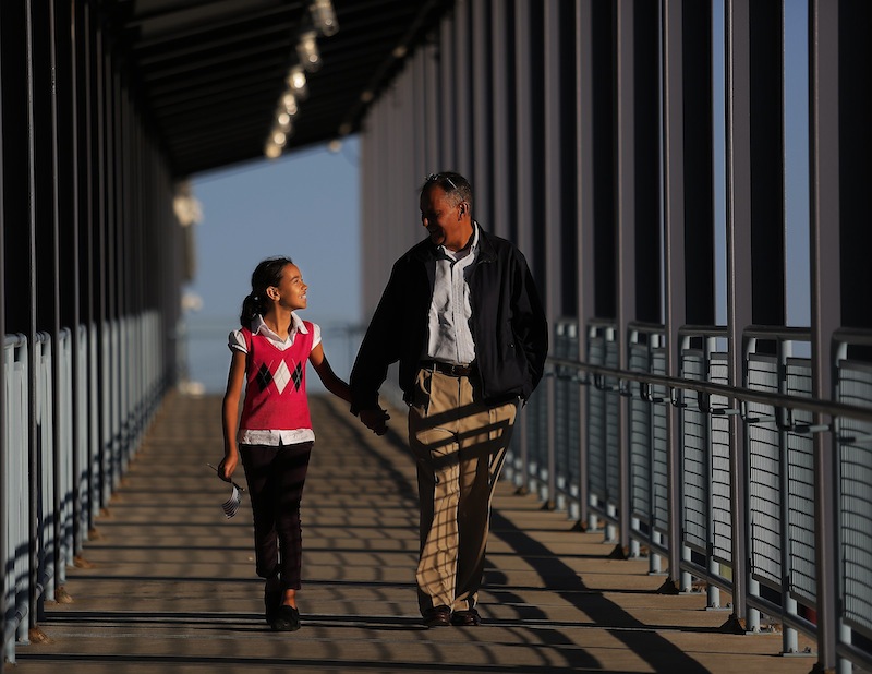 With the American flag in one hand and her father's hand in the other, Charlotte Urquhart of Bangor, left, walks out of Ocean Gateway with her dad Benjamin Urquhart, after Benjamin's wife and Charlotte's mother, Christine Urquhart, originally from France, became a U.S. Citizen at a Naturalization Ceremony on Tuesday, September 17, 2013.