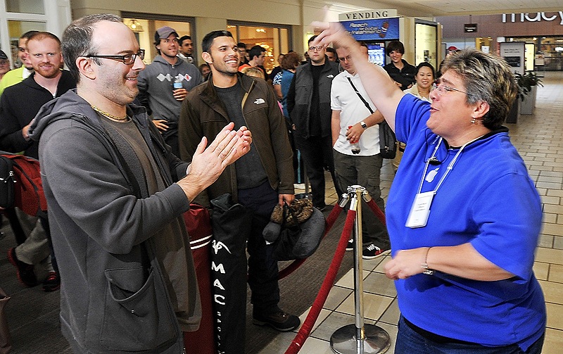 Apple Store leader Pam Famous greets Dan Kennedy of South Portland, who had waited since 3 a.m. Friday for a chance to buy a gold iPhone 5s.