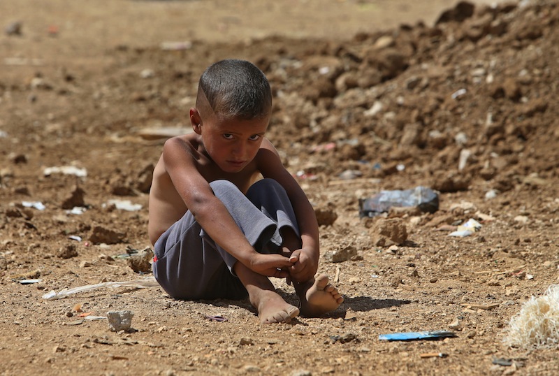 A Syrian refugee sits on the ground at a temporary refugee camp in the eastern Lebanese Town of Al-Faour, Bekaa valley near the border with Syria, on Wednesday, Sept. 11, 2013. Lebanon is a tiny country that shares a porous border with Syria, and has seen cross-border shelling, sectarian clashes and car bombings in recent months related to the civil war raging next door. Key international players were moving on two diplomatic fronts Wednesday, Sept. 11, 2013 to try to put Syria's chemical weapons under international control, and a fresh effort appeared to be underway to get the government and opposition to peace talks. (AP Photo/Hussein Malla)