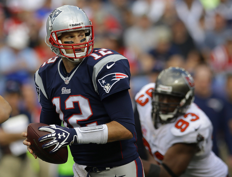 New England Patriots quarterback Tom Brady turns to hand off the ball as Tampa Bay Buccaneers defensive tackle Gerald McCoy moves in during the second half of Sunday's game in Foxborough, Mass.