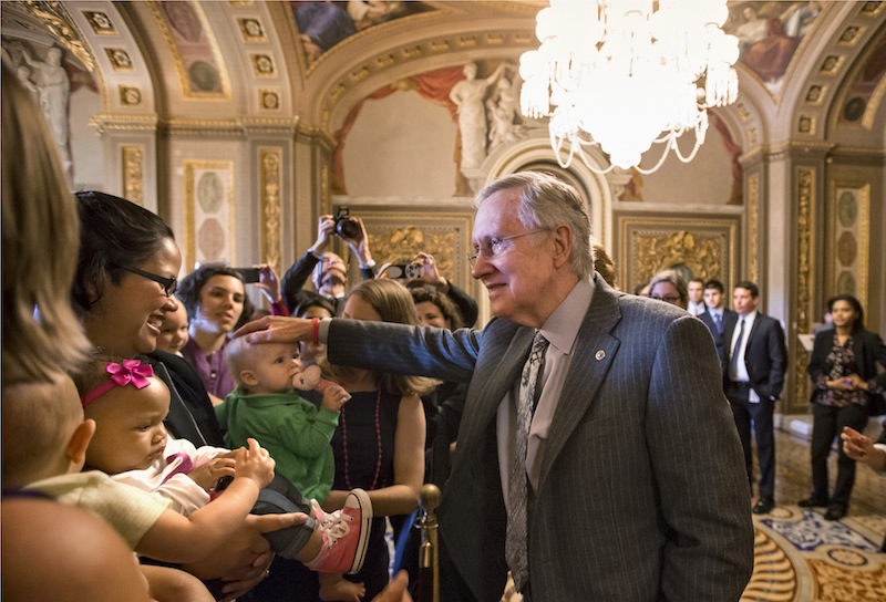 Senate Majority Leader Harry Reid of Nev., and other lawmakers meet with new mothers and their babies on Capitol Hill in Washington, Wednesday, Sept. 25, 2013, to criticize Republican efforts to kill the Affordable Care Act, popularly known as "Obamacare." Sen. Barbara Mikulski, D-Md., said Democrats would defend President Obama's health care law, adding, she would not return to a time when insurance companies denied benefits to women because being a pregnant was considered a preexisting condition. (AP Photo/J. Scott Applewhite)