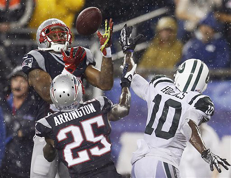 Patriots cornerback Aqib Talib, left, intercepts a pass intended for Jets wide receiver Santonio Holmes (10) in front of Patriots cornerback Kyle Arrington (25) in the fourth quarter Sept. 12 in Foxborough, Mass.