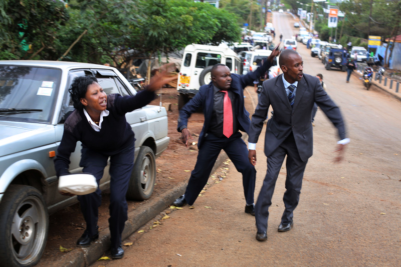 Kenyan security personnel wave at bystanders to take cover as heavy gunfire erupts from the Westgate Mall in Nairobi, Kenya, on Monday.